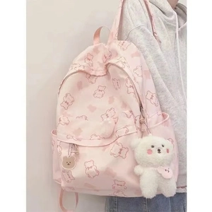 Close-up of pink backpack featuring cute brown bear prints and a plush teddy charm