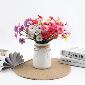 Detail of colorful artificial violet bouquet in white ceramic vase with rustic hemp rope