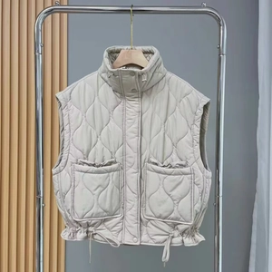 Fashionable beige quilted vest with stand collar, large pockets, and drawstring hem detail