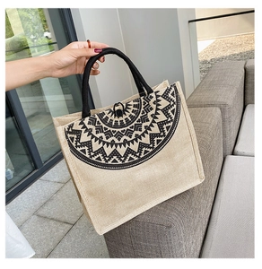 Detailed texture of ethnic hemp tote bag with black geometric pattern and rope handle