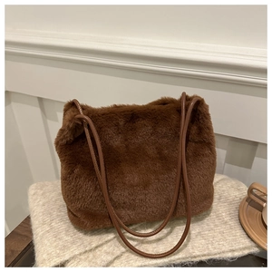 Detail of brown faux fur tote bag showing plush texture and leather shoulder strap