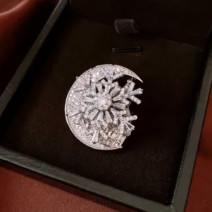 Luxury fashion brooch featuring a crescent moon and snowflake design with zircon stones