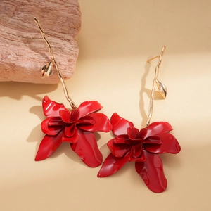 Macro detail of red layered flower earrings with golden branch and leaf elements