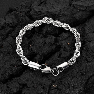 Bracelet chaîne torsadée en acier inoxydable avec fermoir mousqueton sur fond de roche
