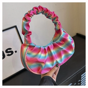 Detail of a vibrant rainbow gradient pleated shoulder bag with silky satin texture