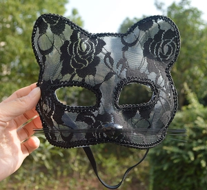 Close-up of black lace cat mask with intricate floral patterns and synthetic whiskers