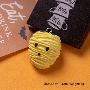Detailed close-up of yellow resin mummy charm with dimensions 2.3cm by 2.8cm