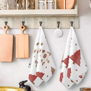 Christmas kitchen towels featuring red and brown pine trees hanging on a wooden hook rack