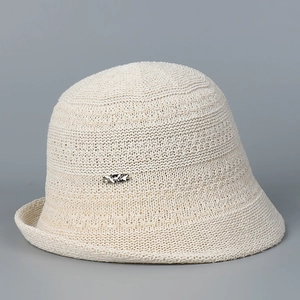 Detail view of beige knit sun hat with rolled edge and elegant silver buckle accent