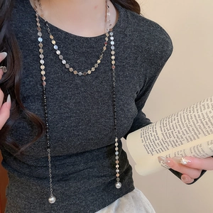 Detail of Y-shaped silver sequin and black bead long necklace with large pearl drop