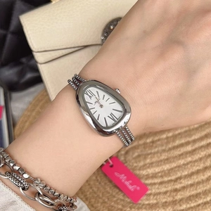 Detail of silver snakehead watch with tassel chain strap and white Roman numeral dial