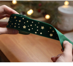 Detail of dark green velvet ribbon with gold star prints for Christmas gift wrapping