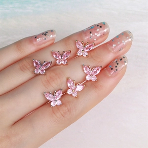 Pink butterfly earrings with sparkling zircon crystals on a hand for a sweet feminine look