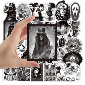 Hand holding a punk style gothic black and white graffiti sticker for suitcases and water bottles