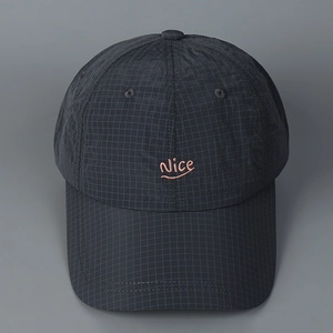 Detailed view of grey checkered fabric texture and pink Nice embroidery on baseball cap