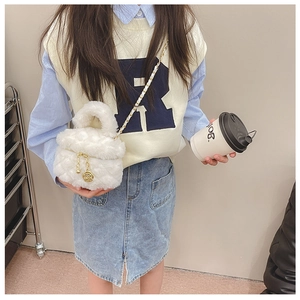 Detailed view of plush white cylinder bag with gold chain strap and rose pendant charm