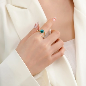 Elegant fishtail open ring with teal gemstone and zircon wings on a gold band