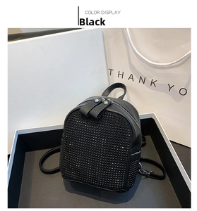Detail of a black rhinestone backpack with dual zippers shown in an elegant gift box set