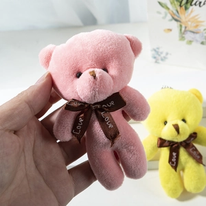 Close-up of pink plush teddy bear keychain featuring a Love printed brown ribbon detail