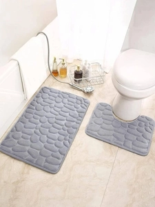 Macro detail of gray pebble textured memory foam bath mat set in a modern bathroom