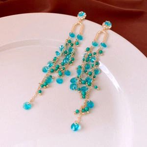 Detail of teal crystal tassel earrings with gold chain and refined French court style