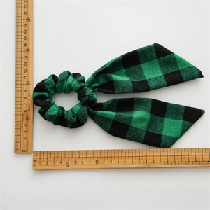 Green and black plaid bow scrunchie for hair, shown with rulers for size measurement