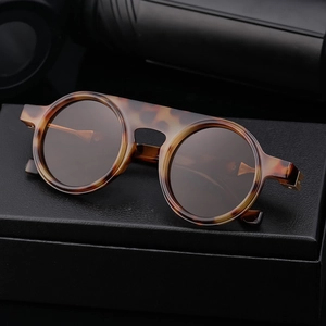 Classic round sunglasses in tortoise shell frame with flat top design on leather case