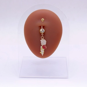 Piercing de nombril doré avec main de squelette tenant une rose rouge et une glace