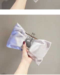 Detail der silbernen Satin-Abendtasche mit Schleife und elegantem Falten-Design