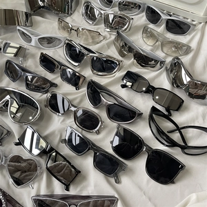 Flat lay of multiple cycling sunglasses in silver, black and white on white cloth
