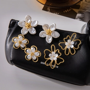 Macro shot of 18K gold opal flower earrings displayed on elegant black leather texture