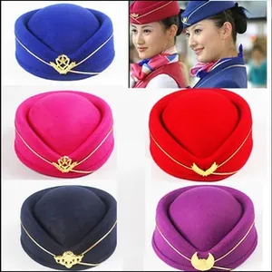 Close-up of airline flight attendant pillbox hats with gold trim and metal badges