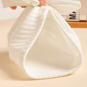 Close-up of soft white ribbed knit fabric showing high elasticity for baby hats