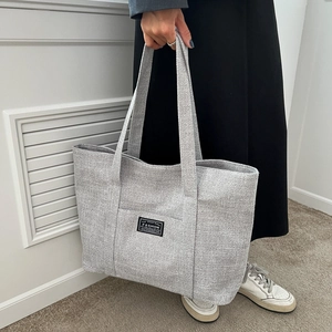 Minimalist grey large canvas tote bag for women showing a stylish shoulder carry look