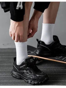 Close-up of black chunky sneakers with white crew socks in a street skating scene