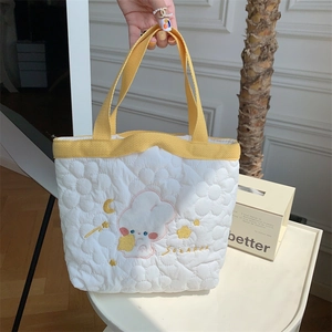 Detailed close-up of quilted floral handbag featuring cute rabbit and star embroidery