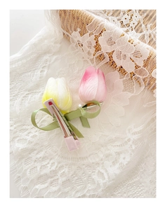 Detailed view of tulip hair clips with silk ribbons, pearls and pink metal duckbill clips