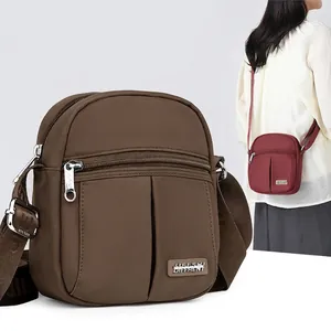 Brown lightweight nylon crossbody bag for women with adjustable letter strap and multiple pockets