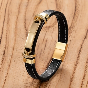 Classic men's braided black leather bracelet with gold stainless steel clasp on wood