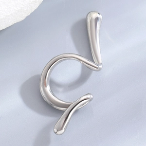 Detailed macro view of silver snake-shaped ear cuff with irregular spiral punk design