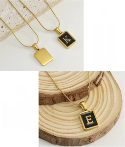 Macro shot of 18k gold stainless steel snake chain with square letter pendants K and E