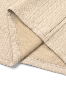 Macro detail of men's knitted fabric showing khaki jacquard texture and premium edge stitching