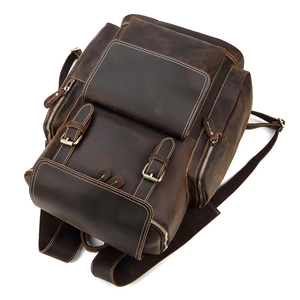 Detail view of crazy horse leather backpack showing dark brown texture and brass hardware