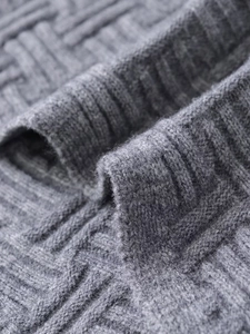 Detailed macro view of the grey ribbed knit fabric and textured weave on the sweater hem