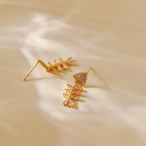 Macro view of fishbone stud earrings with 18K gold plating and inlaid sparkling zircon