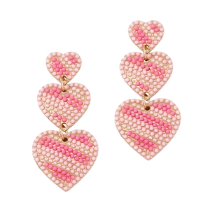 Vintage heart earrings with pink and white beads and rhinestones on white background