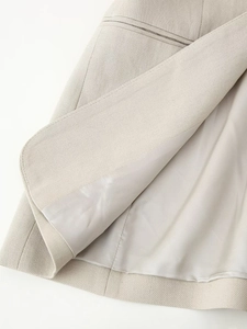 Close-up of beige sleeveless blazer hem showing high-quality cotton linen texture and lining