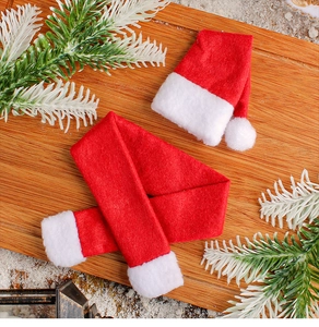 Close-up of mini red Christmas hat and scarf set on a festive rustic wooden board