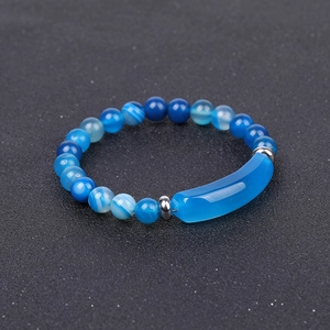 Macro view of blue agate stone beads and silver metal tube on a polished stone bracelet