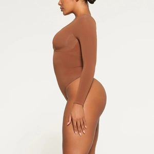 Side view of brown long sleeve slimming bodysuit with high-cut thong design and tight fit